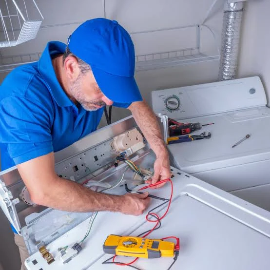 Technician testing laundry appliance controls using a multimeter